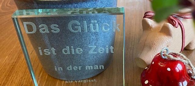Spruch „Das Glück ist die Zeit in der man sie vergisst“ und Glückssymbole
